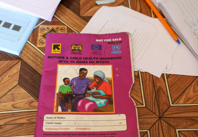 A health handbook used by healthcare workers and mothers like Damac to track and record her child’s health records. This essential tool helps ensure proper monitoring of a child’s growth and nutrition progress.